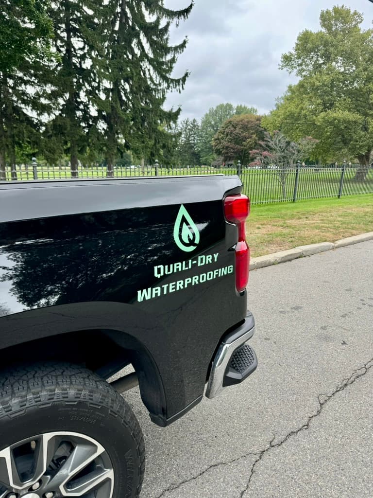 Quali-Dry service truck — branded crew that comes back when the warranty calls
